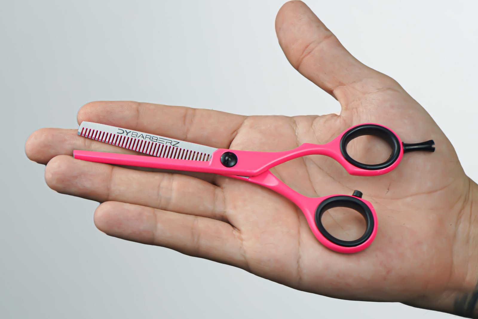 Cinco forma parte de una colección única y exclusiva de Dybarberz, destacándose por su vibrante diseño en rosa neón que enciende cualquier barbería. Con sus dientes afilados y un filo preciso, esta tijera de adelgazado combina elegancia moderna con una artesanía excepcional, ideal para cortes distintivos y personalizados.